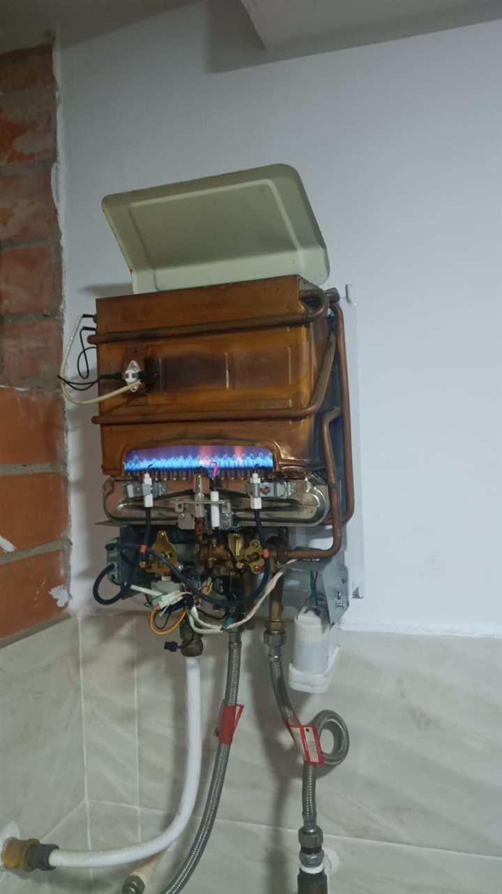 Calentador a gas Challenger encendido después de la reparación en Niquía, Bello, con llama azul estable