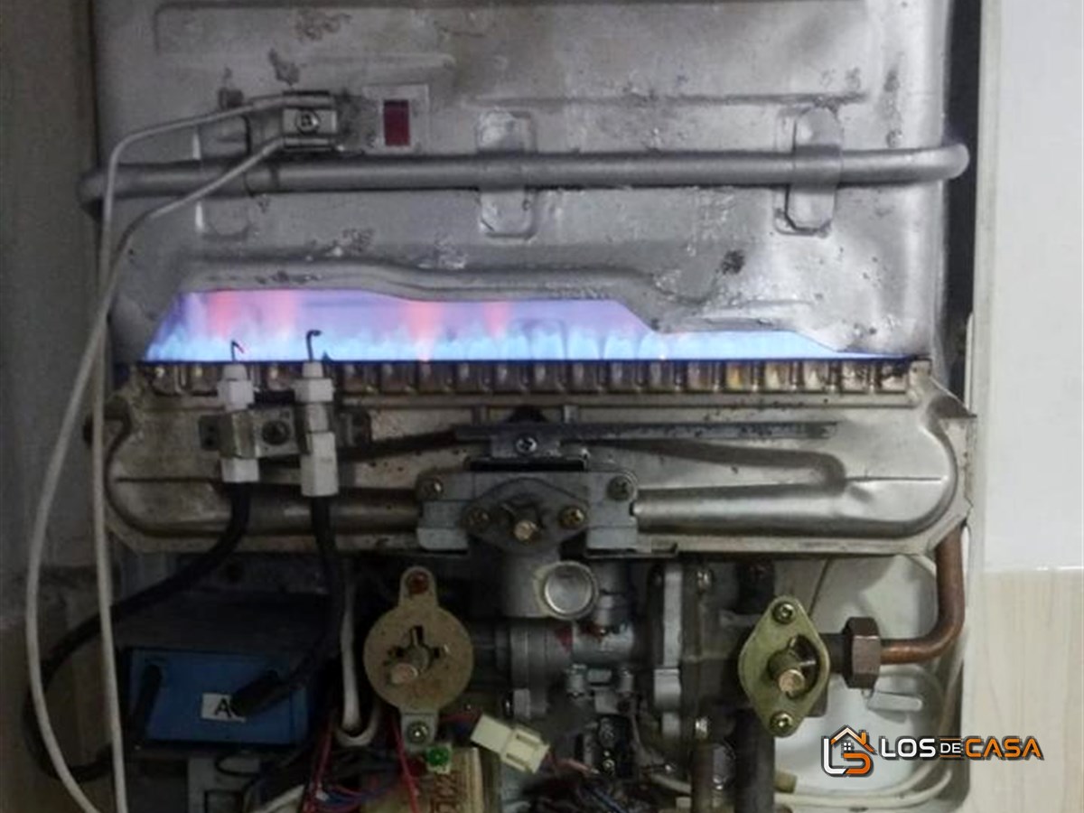 Calentador Haceb encendido después de la reparación, con llama azul pareja en todo el quemador