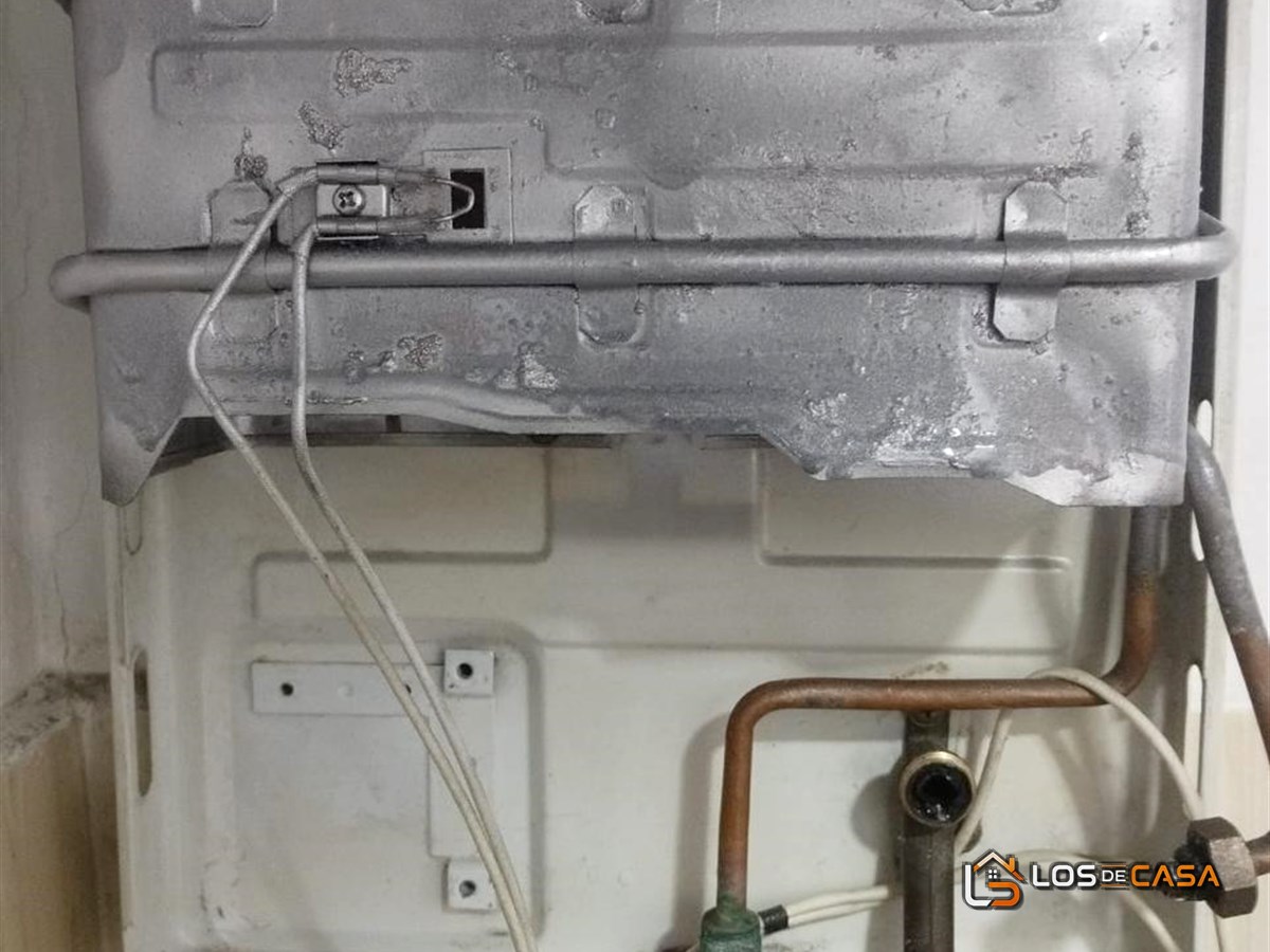 Calentador Haceb destapado durante la reparación, con el cuerpo de agua y la válvula a la vista