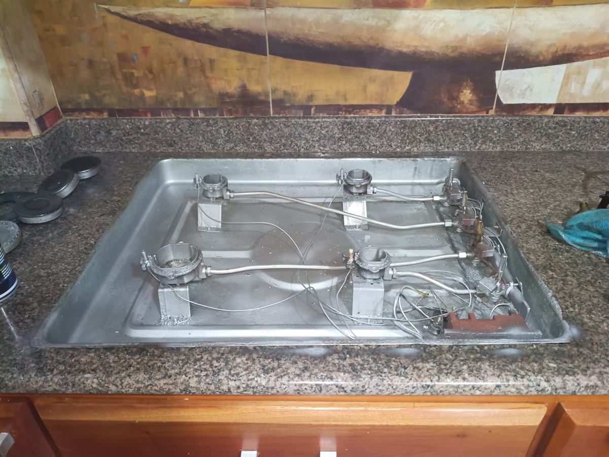 Estufa Haceb con la bandeja, quemadores y conductos ya limpios, lista para instalar las válvulas y empaques nuevos