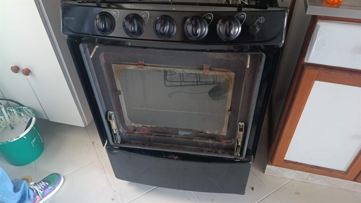 Horno de la estufa Icasa antes del mantenimiento, con suciedad y óxido en la puerta y el marco del vidrio